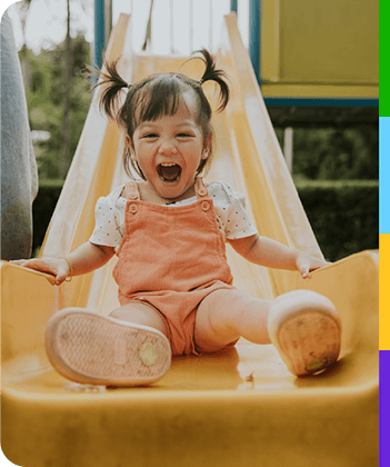 Representación actoral de un niño pequeño bajando emocionado por un tobogán