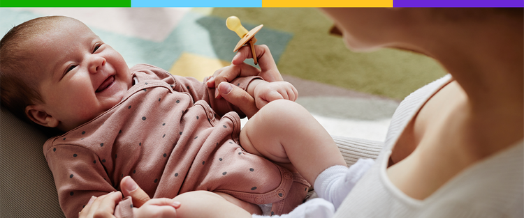 Representación actoral de un bebé con un chupón que sonríe a sus padres